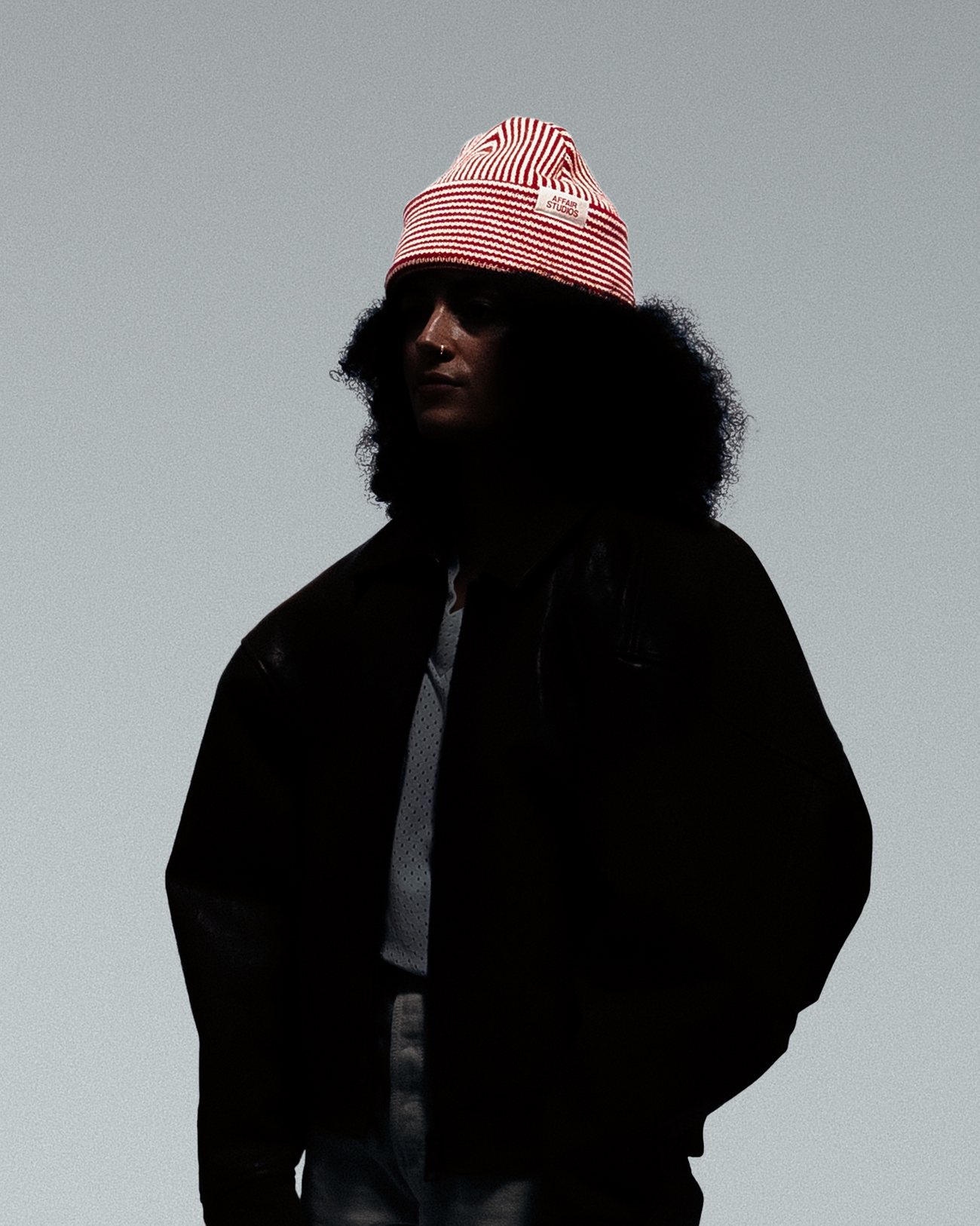 Model in a red and ecru striped Affair Studios beanie