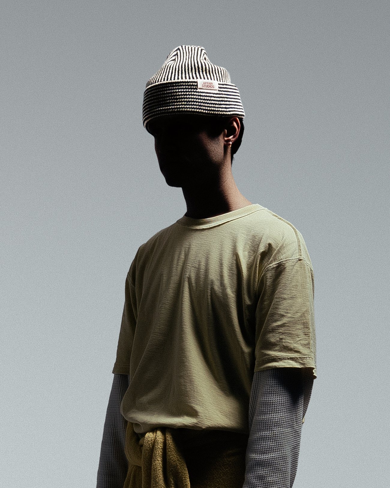 Model in a black and ecru striped Affair Studios beanie